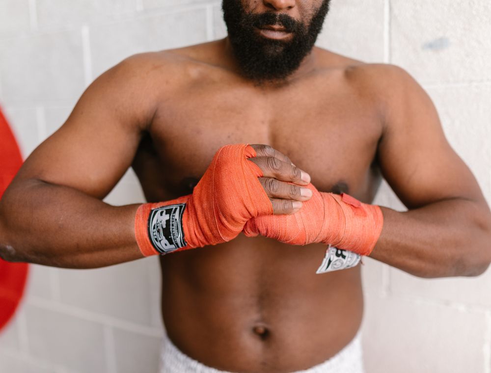 Fighter wrapping hands with orange boxing bandages