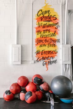 Gym wall with motivational quotes and exercise balls against a white background.