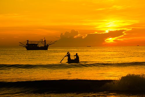 Free Silhouette of people in a boat during a stunning Vietnam sunset on the ocean. Stock Photo