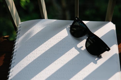 Photo of Black Sunglasses on Top of Braille