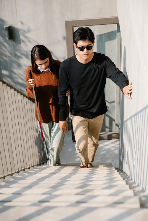 Free Photo of Woman Assisting Man to Walk Up the Stairs Stock Photo