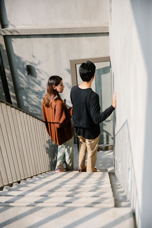 Free A man and woman descending an outdoor staircase together in daylight. Stock Photo