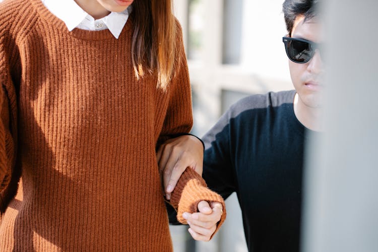 Shallow Focus Photo Of Man Holding Woman's Arm 