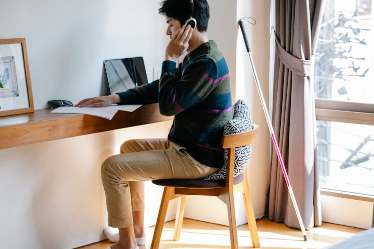 Photo Of Man Using Headphones While Learning Braille