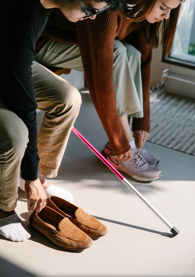 Photo Of Man And Woman Putting On Shoes