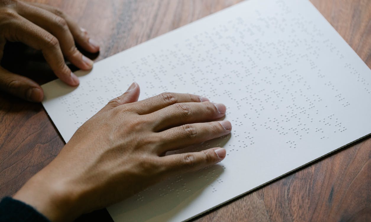 Close-Up Photo Of Person Using Braille 