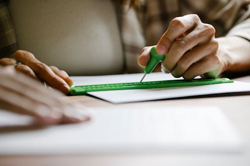 Close-Up Photo Of Person Using Stylus And Slate