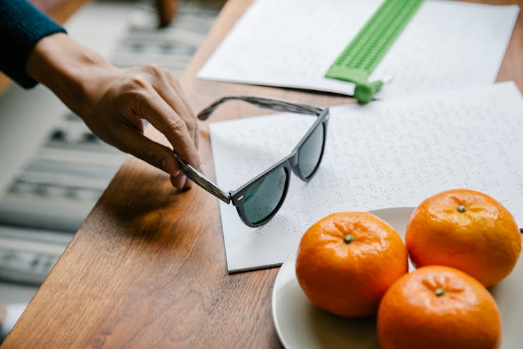 Photo Of Person Picking Up His Sunglasses