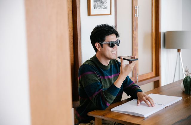 A person smiling while making a call to plan a surprise