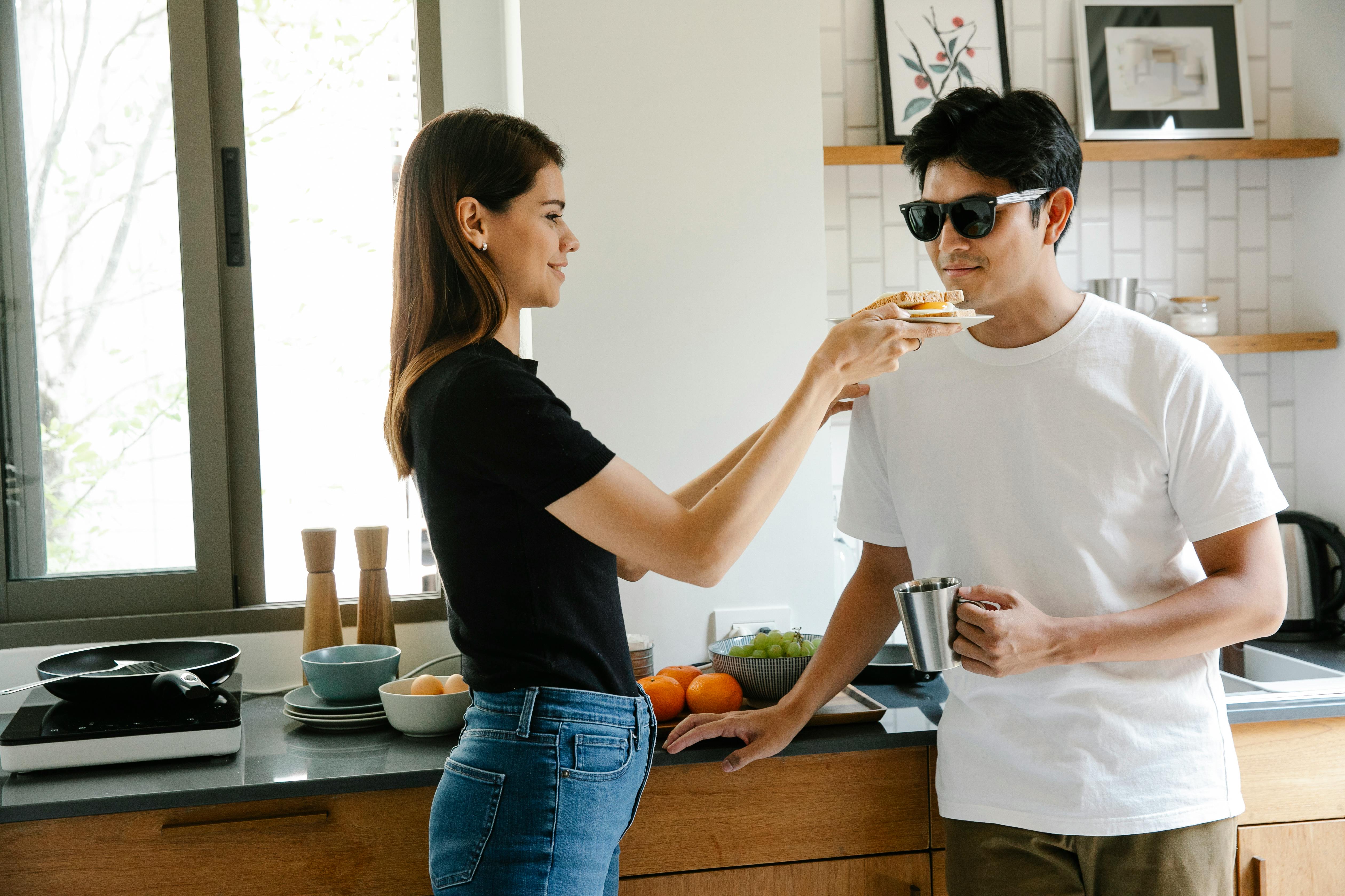 A smiling couple shares breakfast in a cozy kitchen, highlighting love and care.
