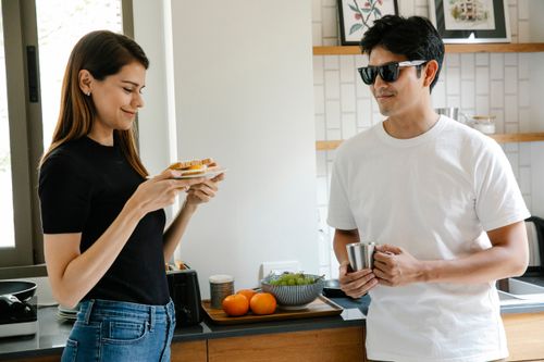 Free A couple shares a casual breakfast in a modern kitchen, reflecting happiness and togetherness. Stock Photo