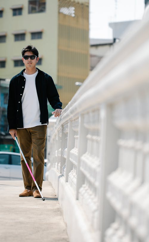 Photo Of Man Walking On Sidewalk