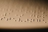 Macro shot of Braille dots embossed on paper, illustrating tactile reading for visually impaired.
