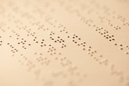 Detailed macro shot of Braille dots embossed on paper, highlighting texture and pattern.