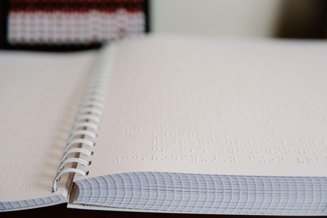 Detailed view of open pages of a Braille book focusing on the tactile text.