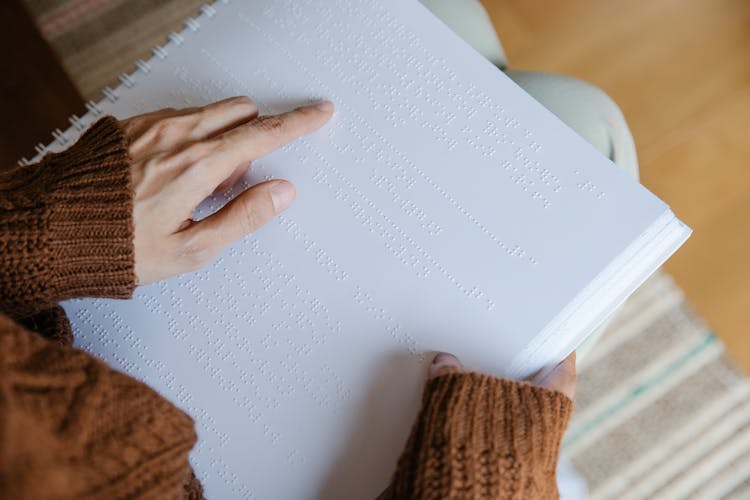 Photo Of Person Pointing On Braille