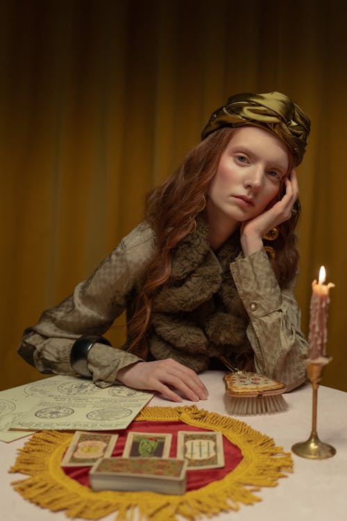 Woman Posing at the Table with Cards and Candle