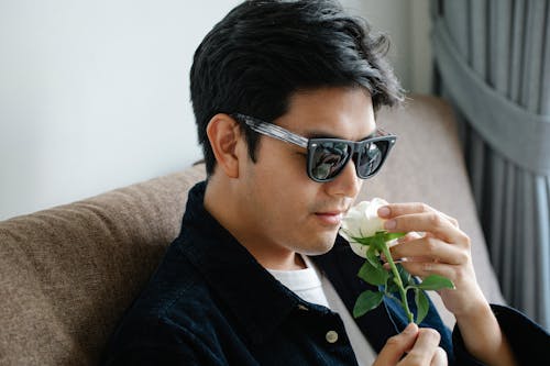 Photo of Man Smelling White Rose