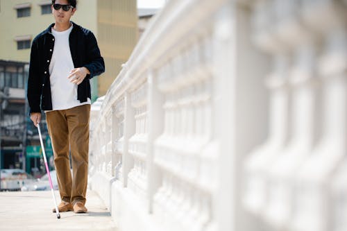 Photo Of Man Walking On Sidewalk