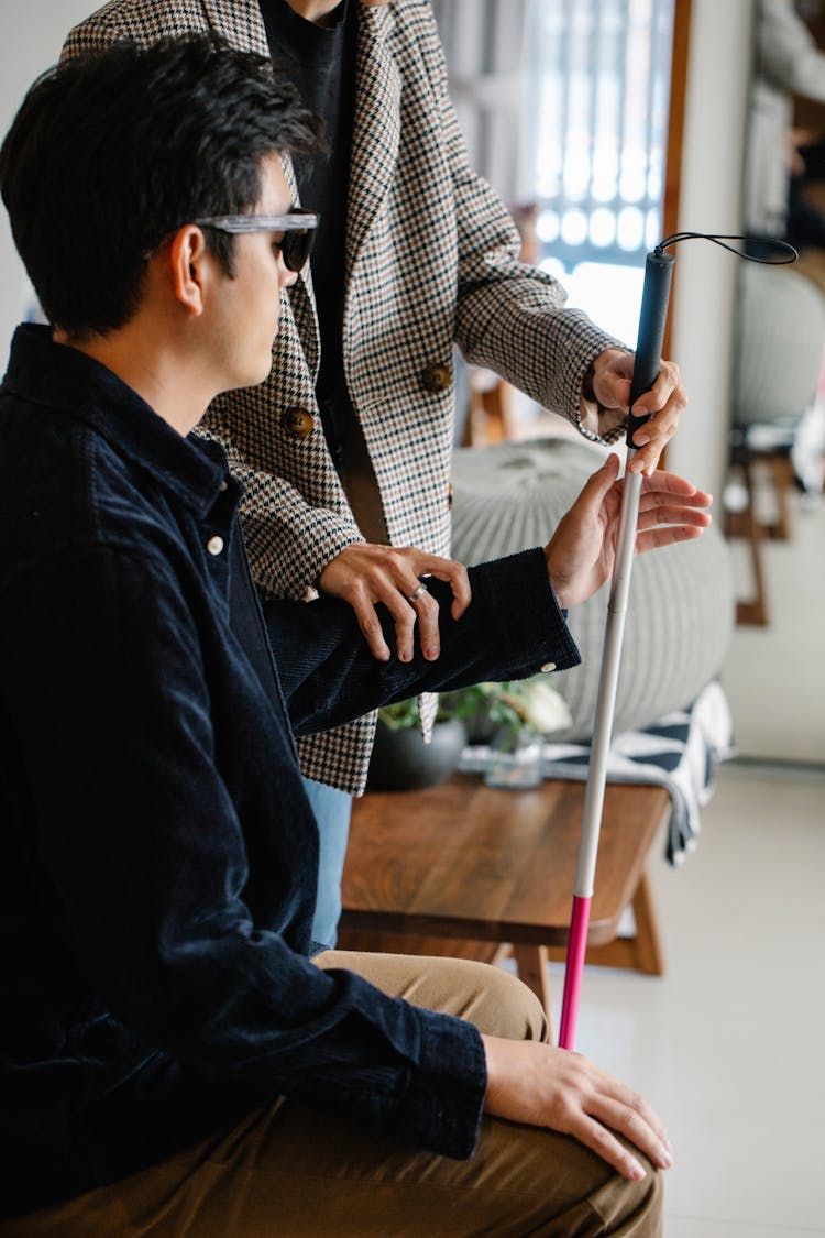 Photo Of Person Helping Man Get His Walking Stick 