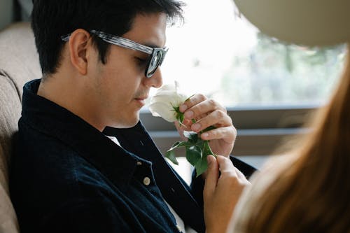 Photo of Man Smelling Flowers