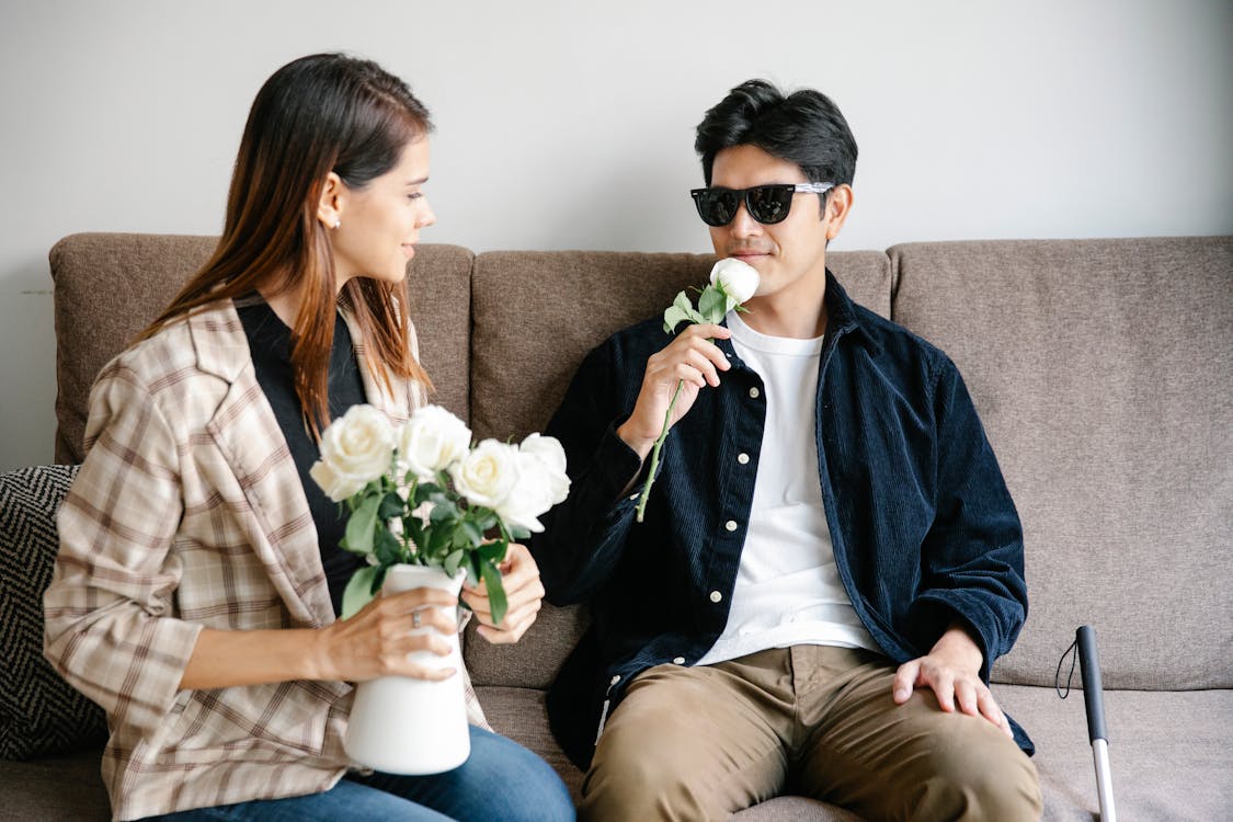 Photo of Man Smelling White Rose