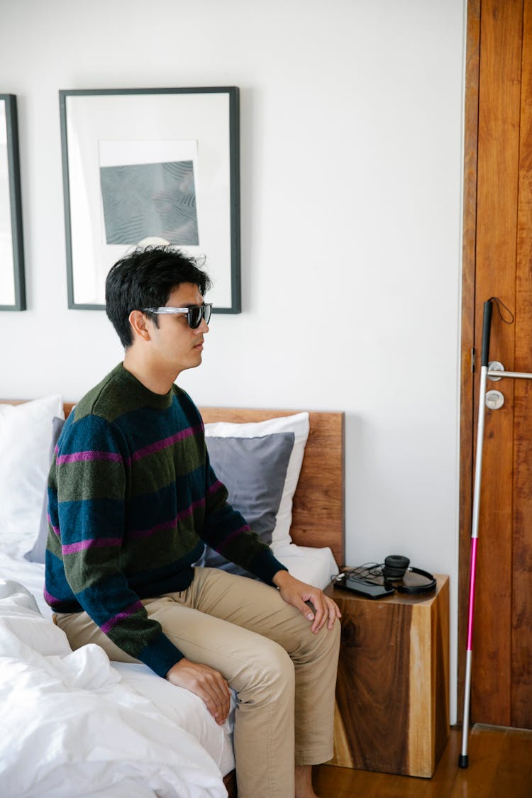 Photo Of Man Sitting On The Bedside 