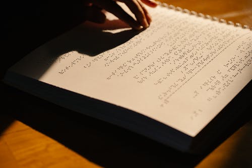 Close-Up Photo of Person Using Braille 