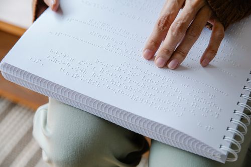 Free Detailed close-up of hands using tactile perception to read a braille book. Stock Photo