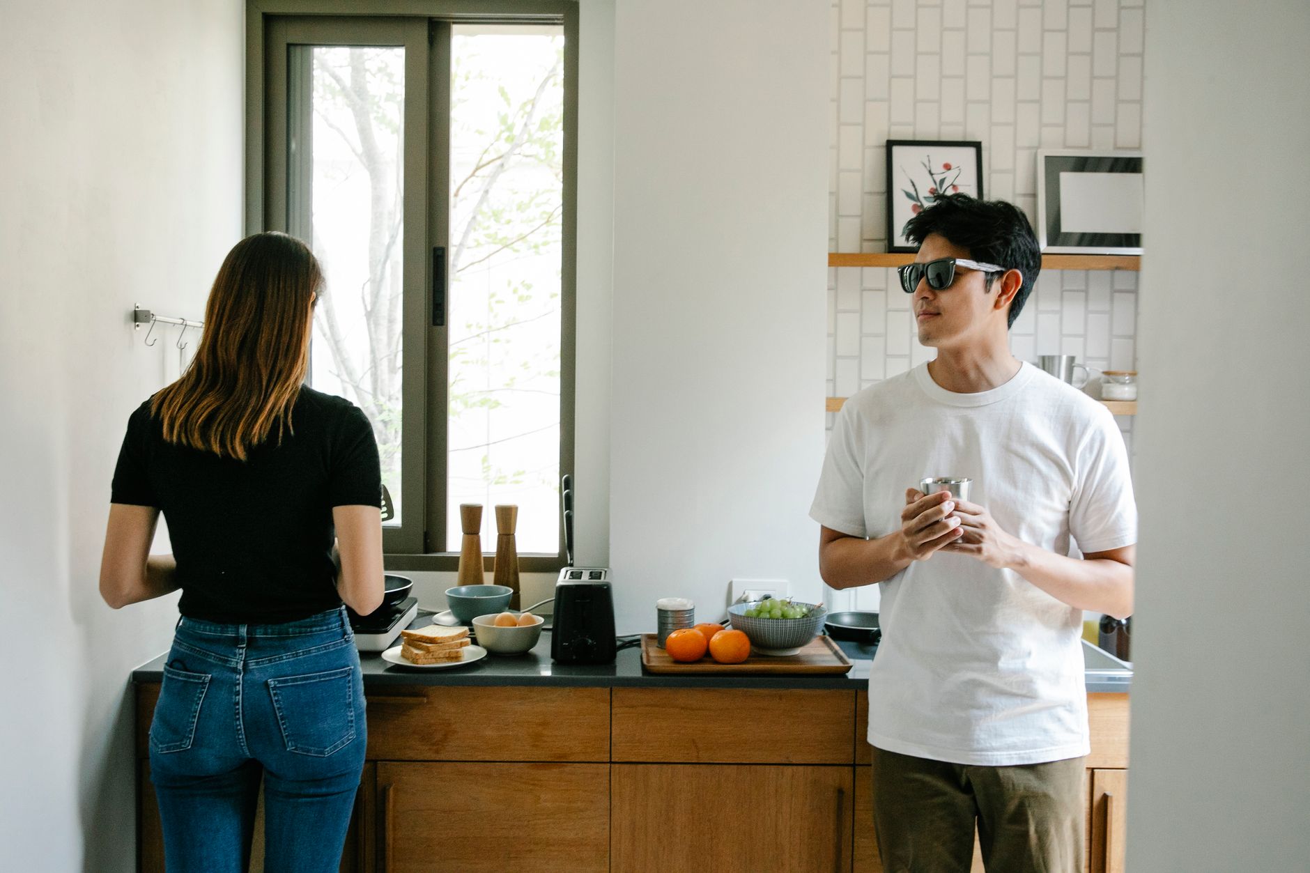 A man and woman preparing food in a modern kitchen, focusing on casual interaction and lifestyle.