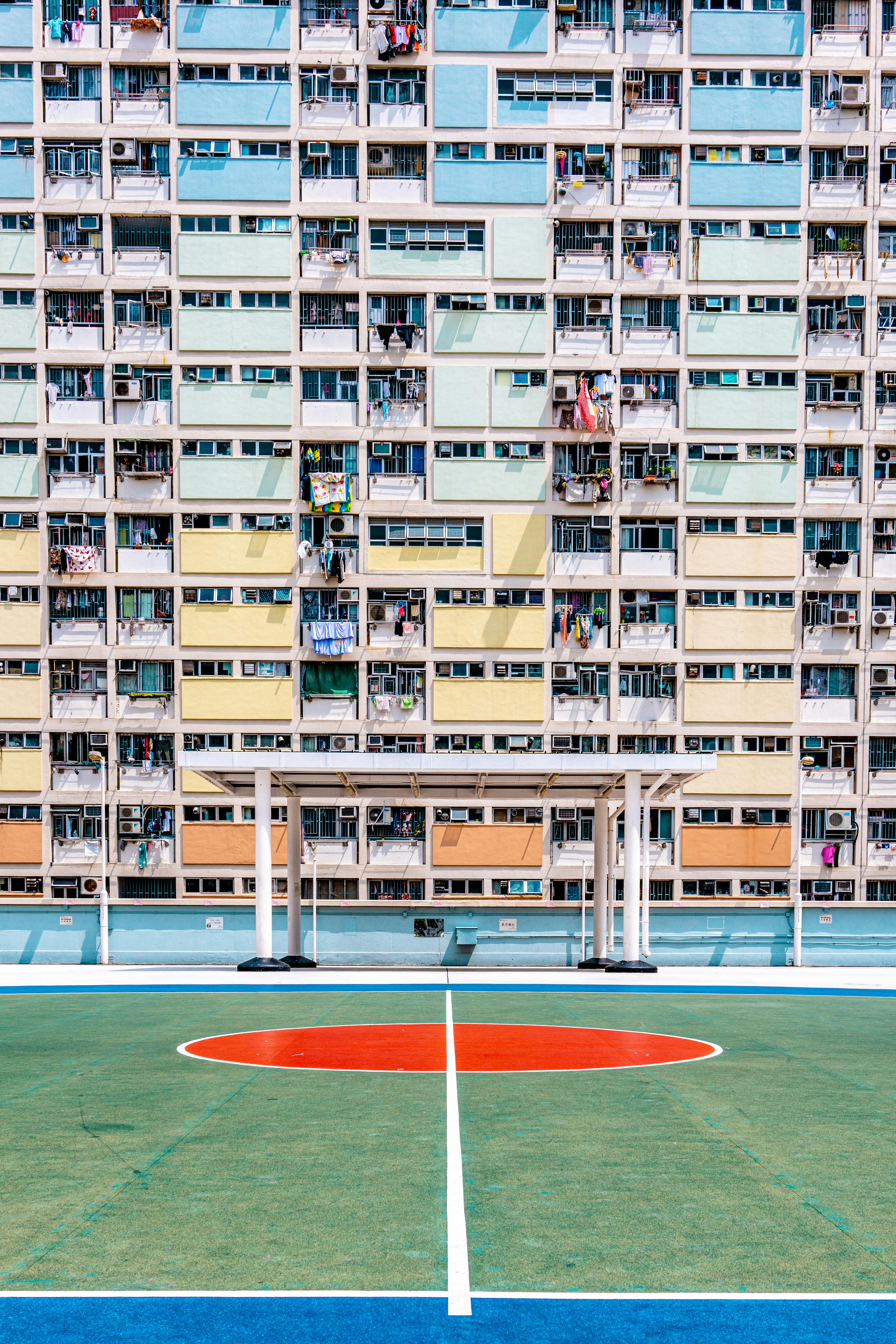 Vibrant basketball court set against a colorful apartment building facade in an urban cityscape.
