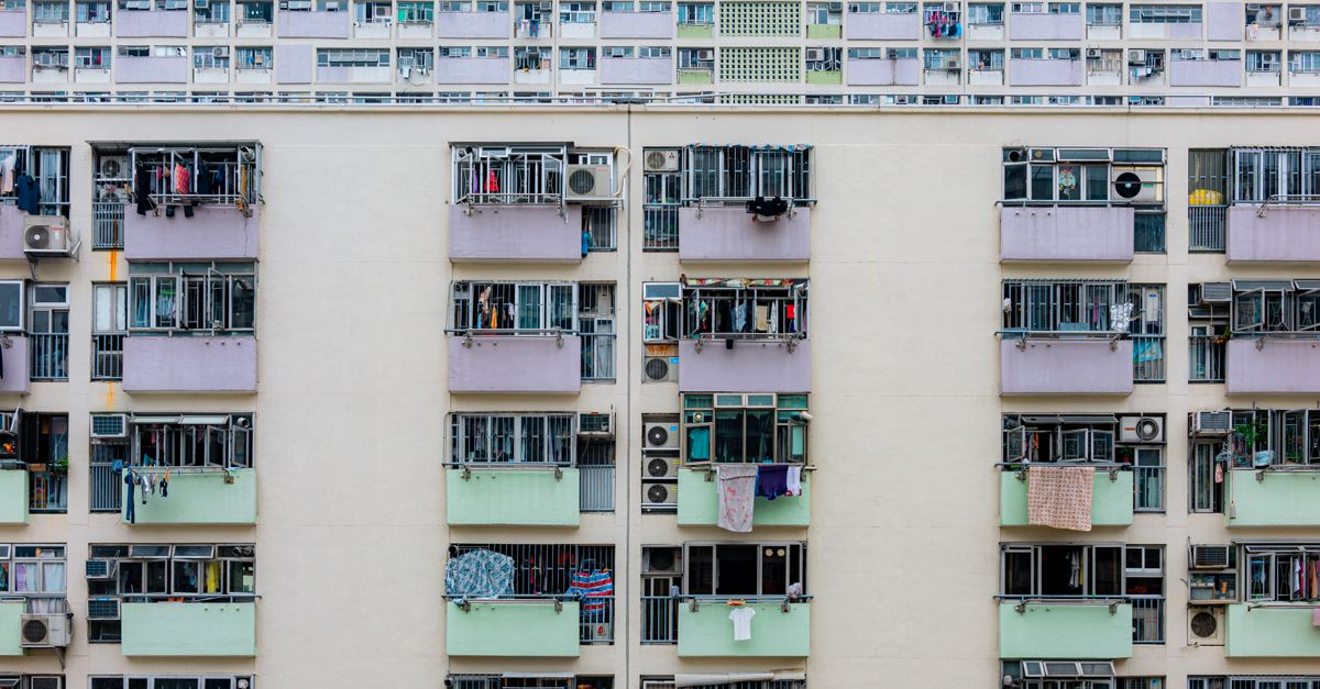 Multicolored urban apartment building with balconies and windows, showcasing city living.