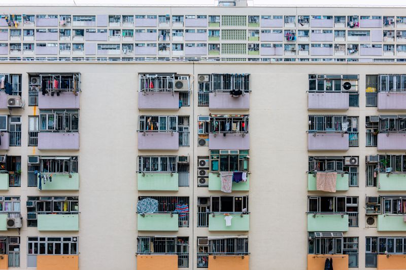 Multicolored urban apartment building with balconies and windows, showcasing city living.