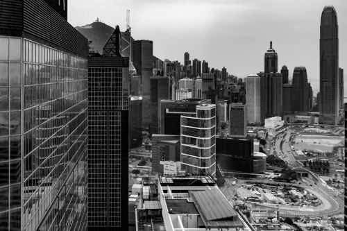 Free A dramatic black and white view of Hong Kong's modern skyline featuring towering skyscrapers. Stock Photo
