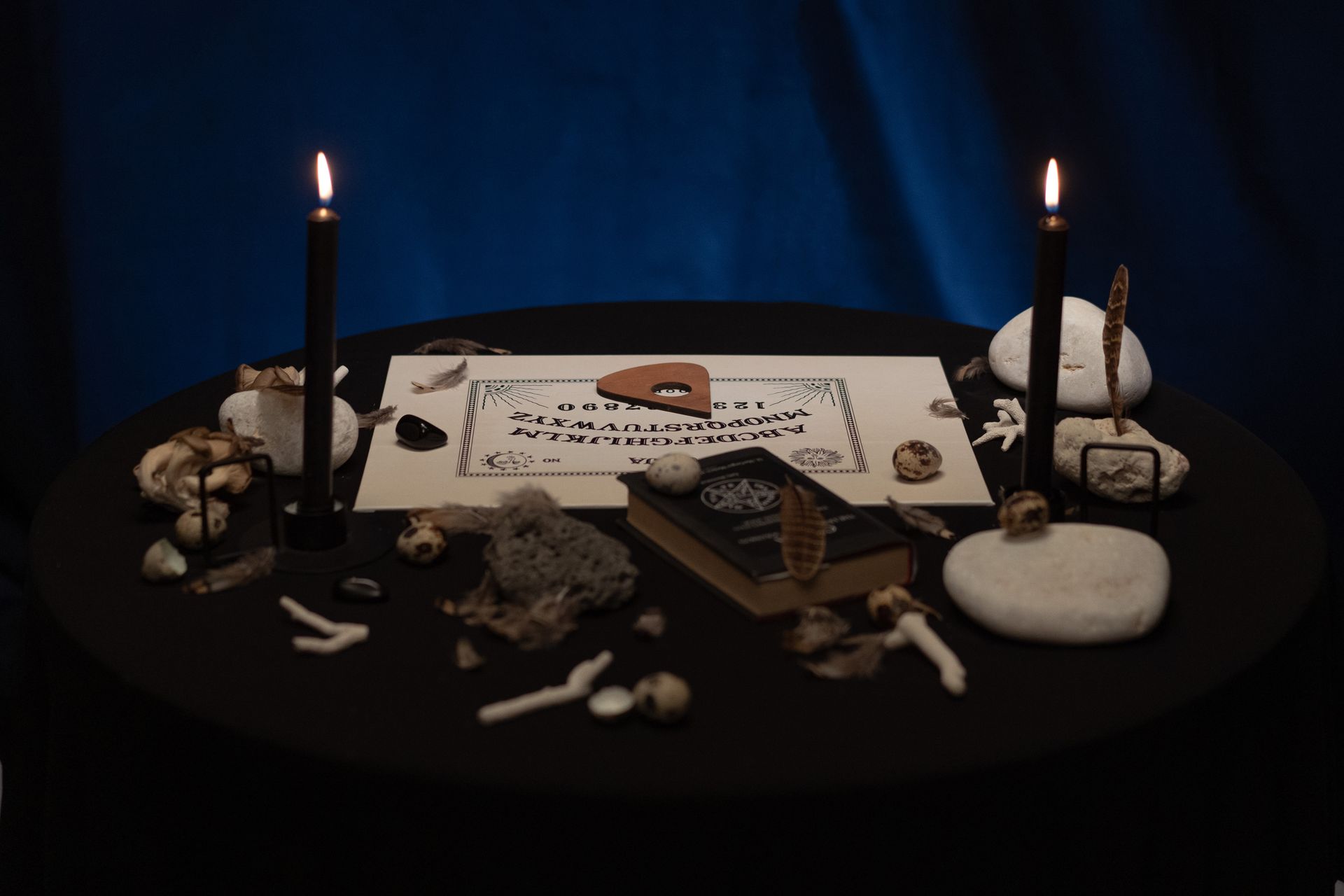 Materials for Witchcraft and Burning Candles on a Round Table