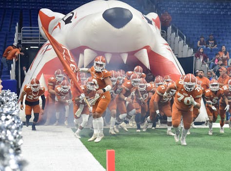 A dynamic scene of an American football team entering the stadium with enthusiasm, leading with a flag.