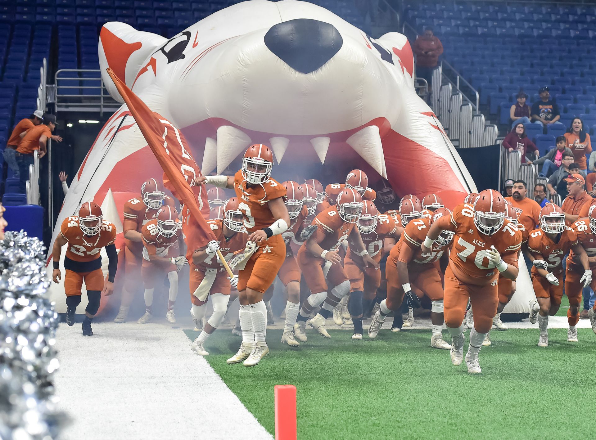Football Team Running Thru Football Field