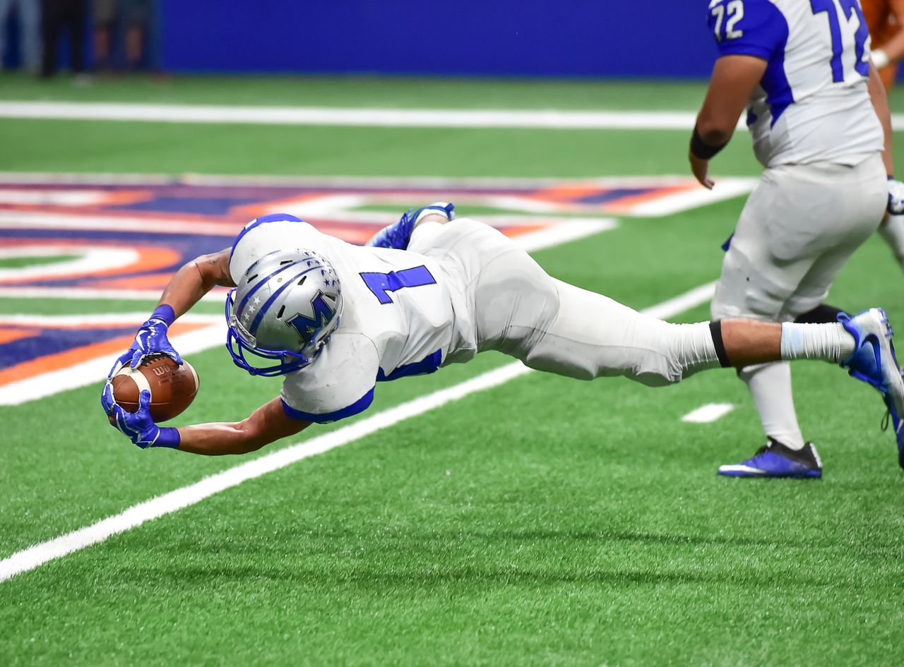 football player making an incredible diving catch during a high energy