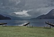 在英国坎布里亚郡宁静的湖滨，壮观的天空下设有长凳和码头