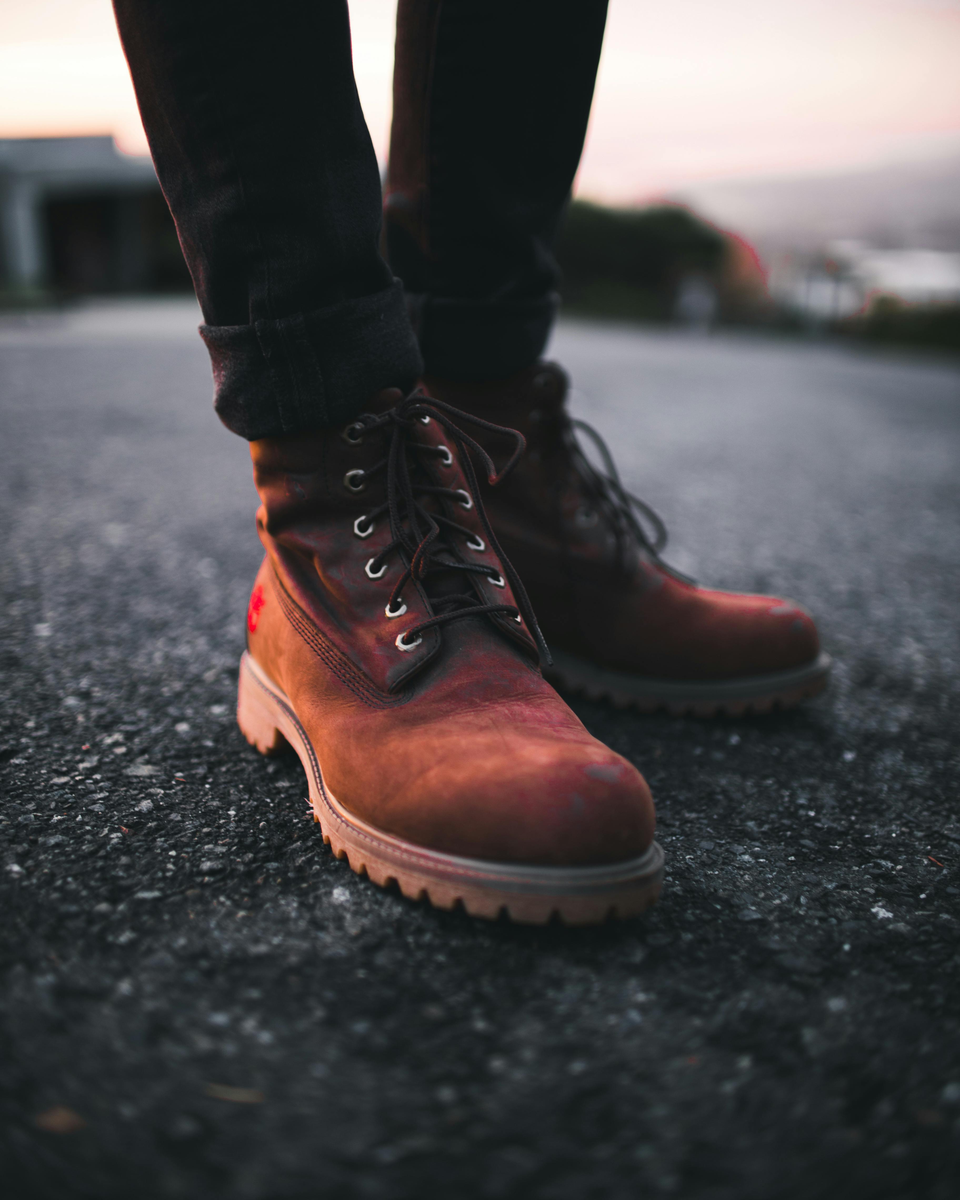 Person of Brown Timberland Work Boots and Black Denim Skinny Jeans on Asphalt Road · Free Stock Photo