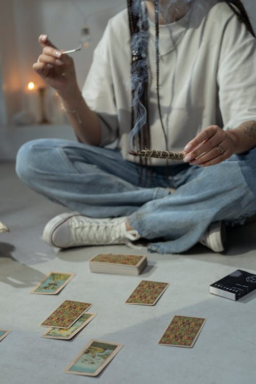 Free Woman Sitting on the Floor Beside Tarot Cards and Burning Herbs Stock Photo