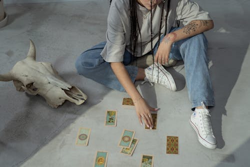 A Woman Holding a Tarot Card on the Floor