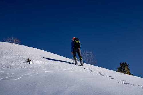 Free Man Hiking on a Snow Covered Hill Stock Photo