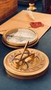 Golden Sundial and Compass on Gray Table