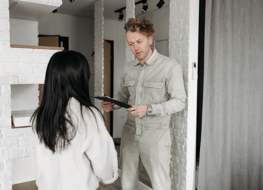 A technician greeting a homeowner at the door with the paperwork