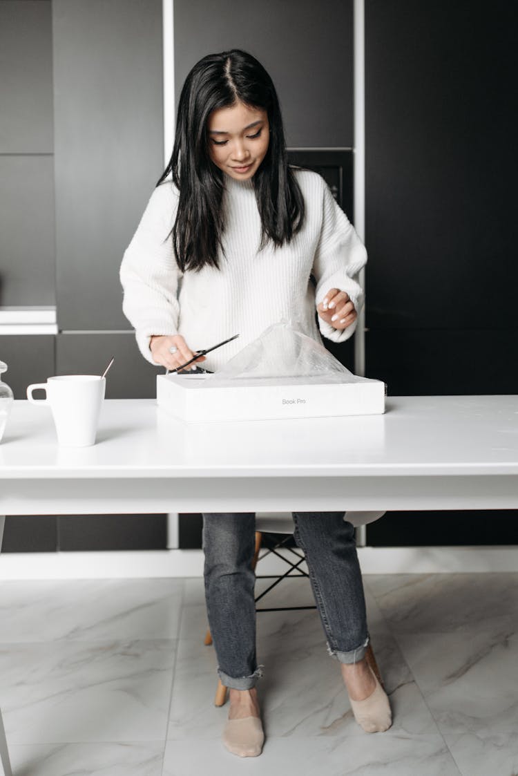 A Woman Unboxing A Macbook Pro Laptop