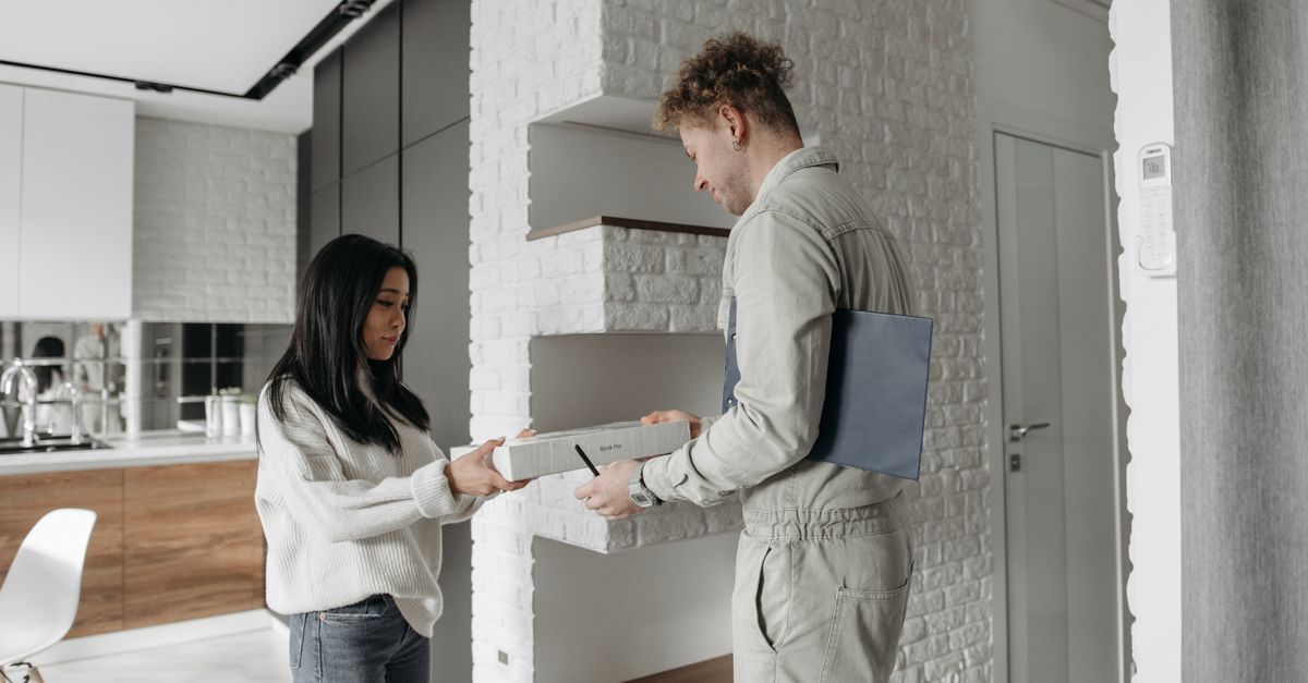 Técnico de servicios del hogar en la puerta de un cliente satisfecho