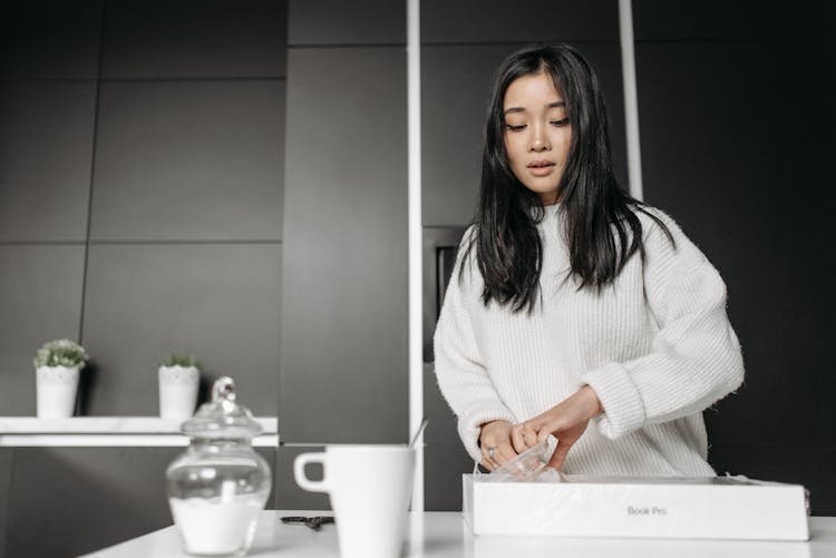 Woman In White Sweater Unpacking White Box Parcel