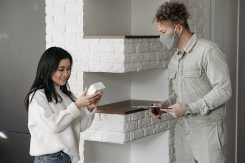 Woman Receiving a Parcel from Deliveryman
