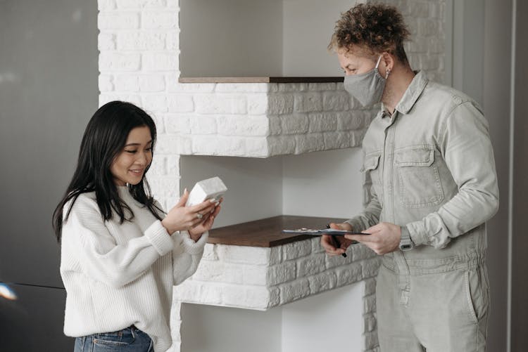 Woman Receiving A Parcel From Deliveryman